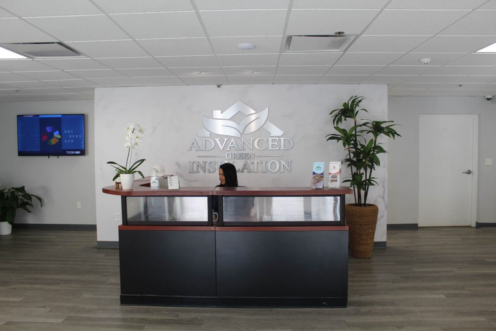 Inside the Advanced Green Insulation lobby - front desk with silver logo behind